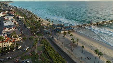 giro aéreo lento sobre el muelle en san clamante, california, justo antes de la puesta del sol