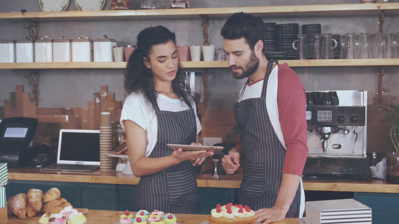 animación de gráficos moviéndose sobre compañeros de trabajo multirraciales discutiendo sobre tableta digital en un café