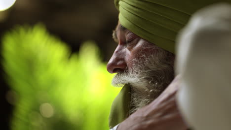 Primer-Plano-De-Un-Estudio-De-Un-Hombre-Sikh-Mayor-Con-Barba-Que-Usa-Una-Aguja-De-Salai-Mientras-Se-Pone-Un-Turbante,-En-Tiempo-Real