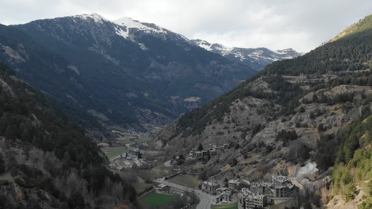 Aerial view of Andorran mountain valley with small village nestled among snow-capped peaks. Scenic Pyrenees landscape, travel destination, Andorra