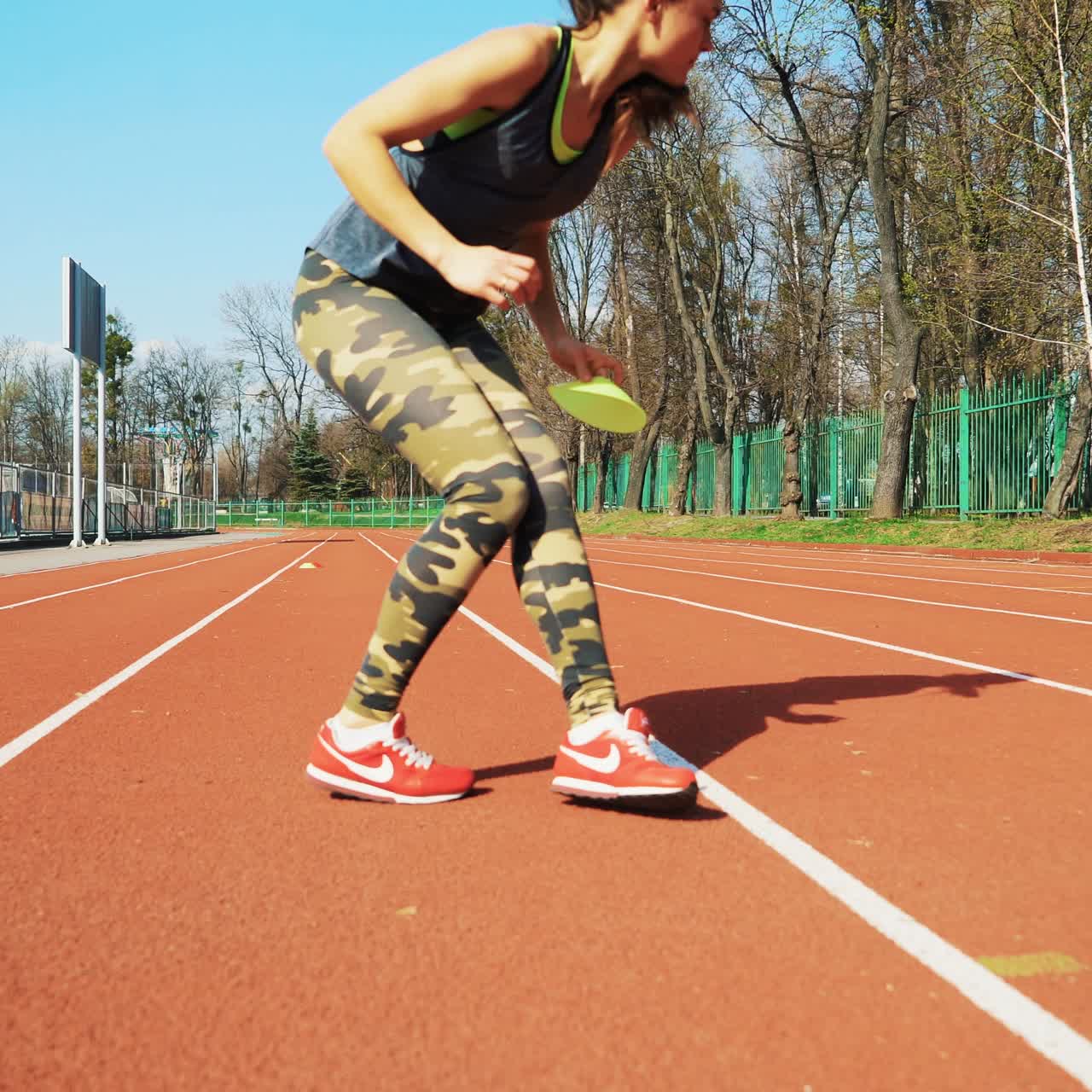 Young woman go in for sport run at the stadium track in the morning. Summer outdoors training