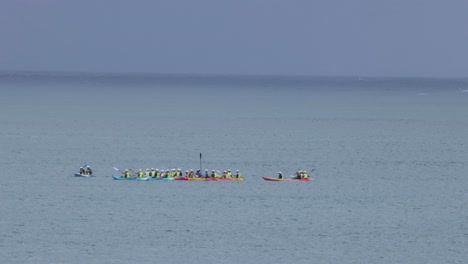 multiple kayaks competing in a tranquil water setting