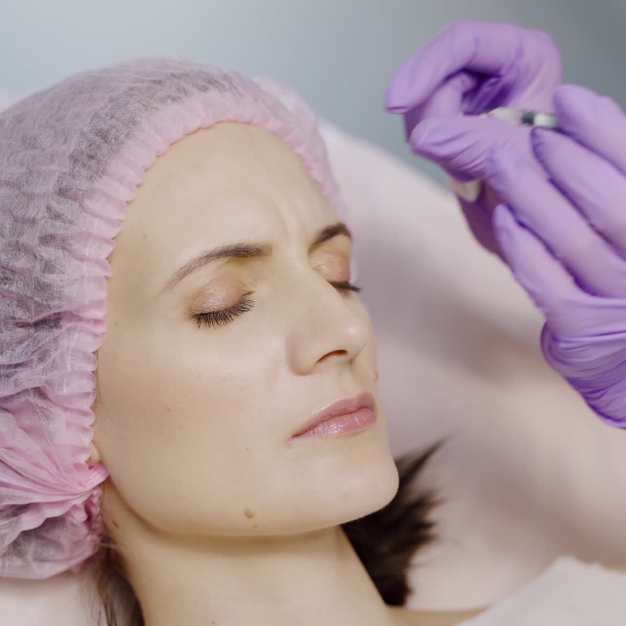 Beautician gently makes Botox using a needle for the client. Preventing wrinkles. Beauty injections