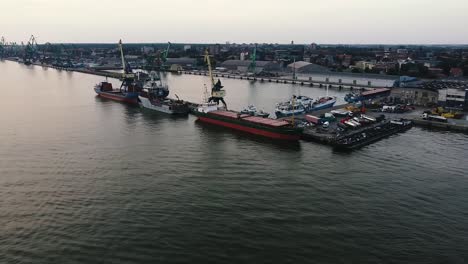 Filmische-Luftdrohnenaufnahme-Von-Schiffen-Im-Hafen,-Die-Auf-Die-Beladung-Warten,-Bevor-Sie-Ins-Meer-Gehen