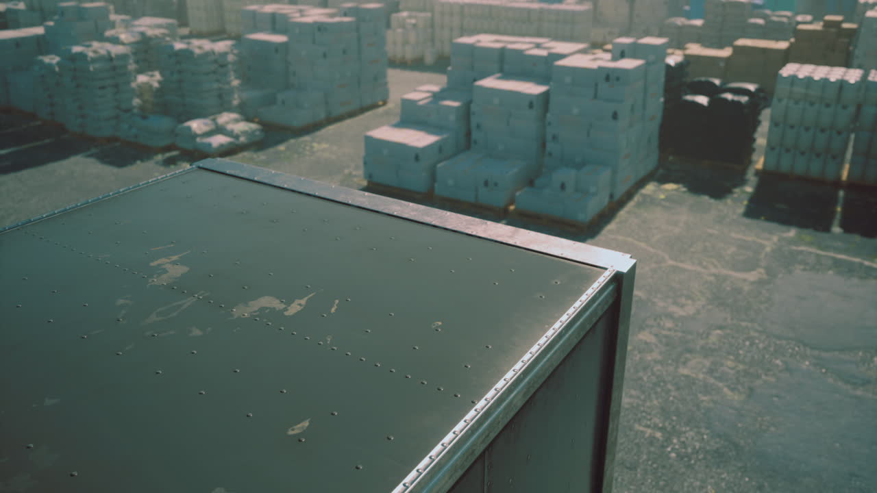 Storage containers stacked at a busy shipping yard during daylight hours