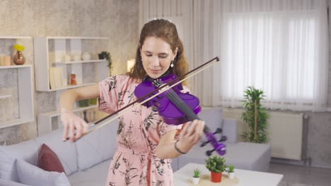 inspirational talented musician woman playing violin at home and happy.