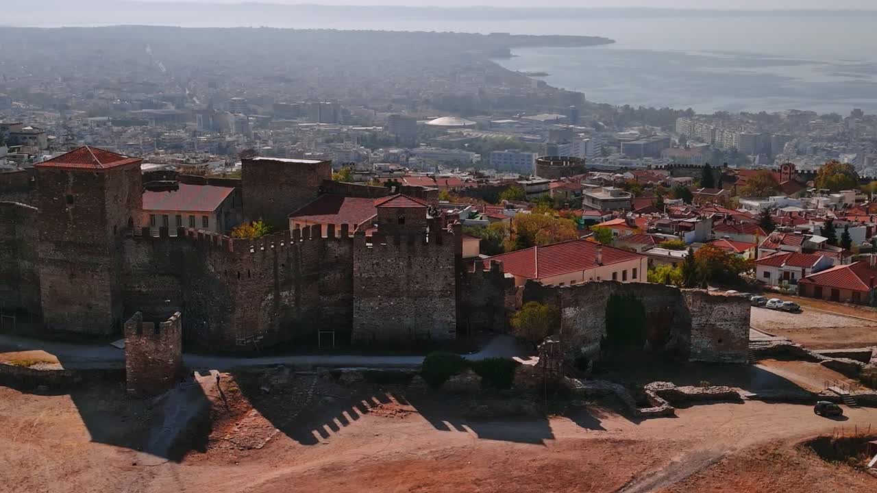 Vistas de um castelo antigo e de uma cidade costeira na Grécia durante o dia.