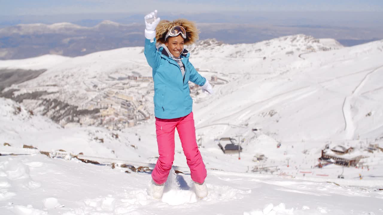 una mujer linda con ropa de esquí pateando nieve.