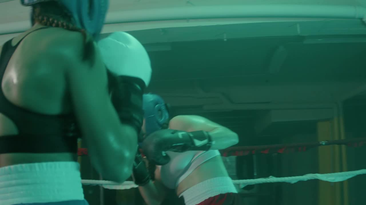 헬멧을 쓴 두 명의 여성 복서와 링에서 훈련하는 권투 장갑