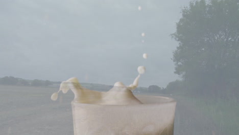 splashing milk in glass with countryside landscape, trees, and cloudy sky animation