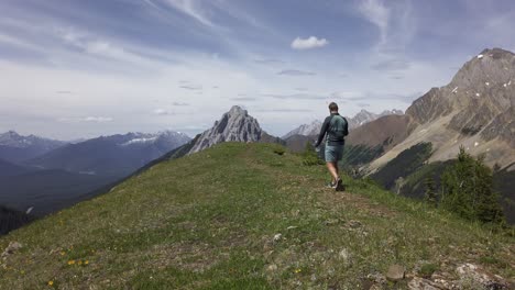 excursionista caminando en la cima de un avión de montaña tomando fotografías de las montañas rocosas, kananaskis, alberta, canadá