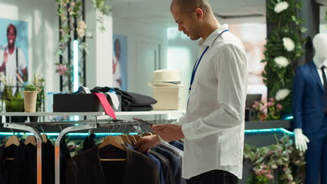hombre comprobando el inventario en una tienda de ropa moderna