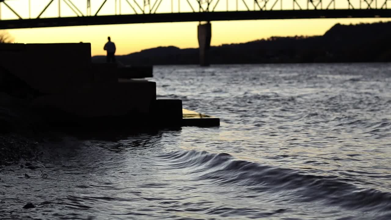A silhouetted man and woman take pictures and have a good time
