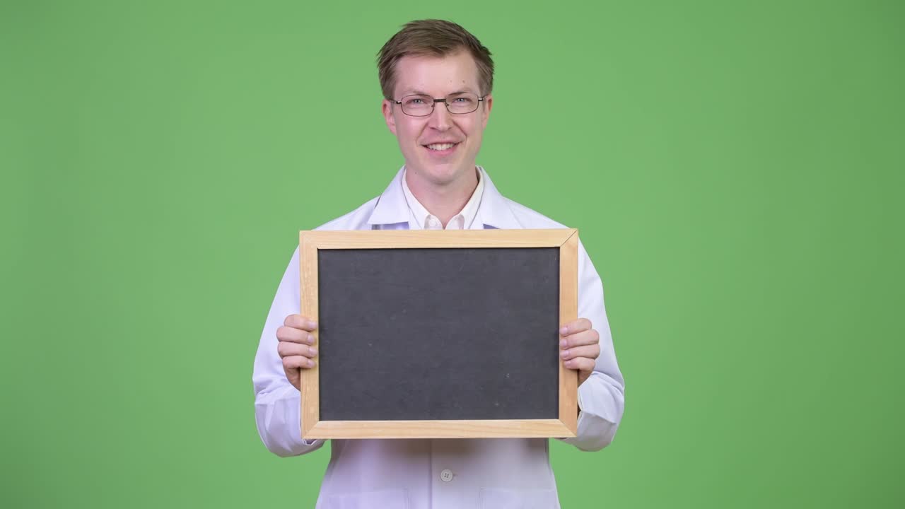 Happy Man Doctor Holding Empty Blackboard With Copyspace