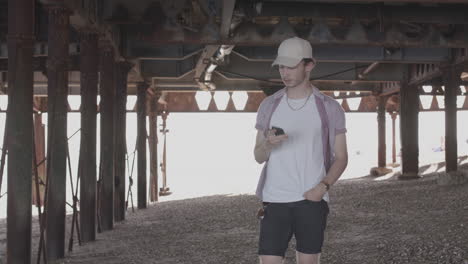 man walking under pier and receives a phone call from a good friend - ungraded