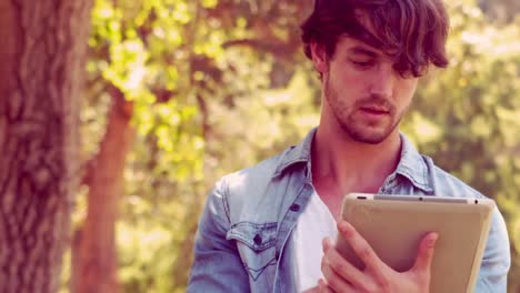 Hipster-Mann-Benutzt-Tablet-Computer-Im-Park