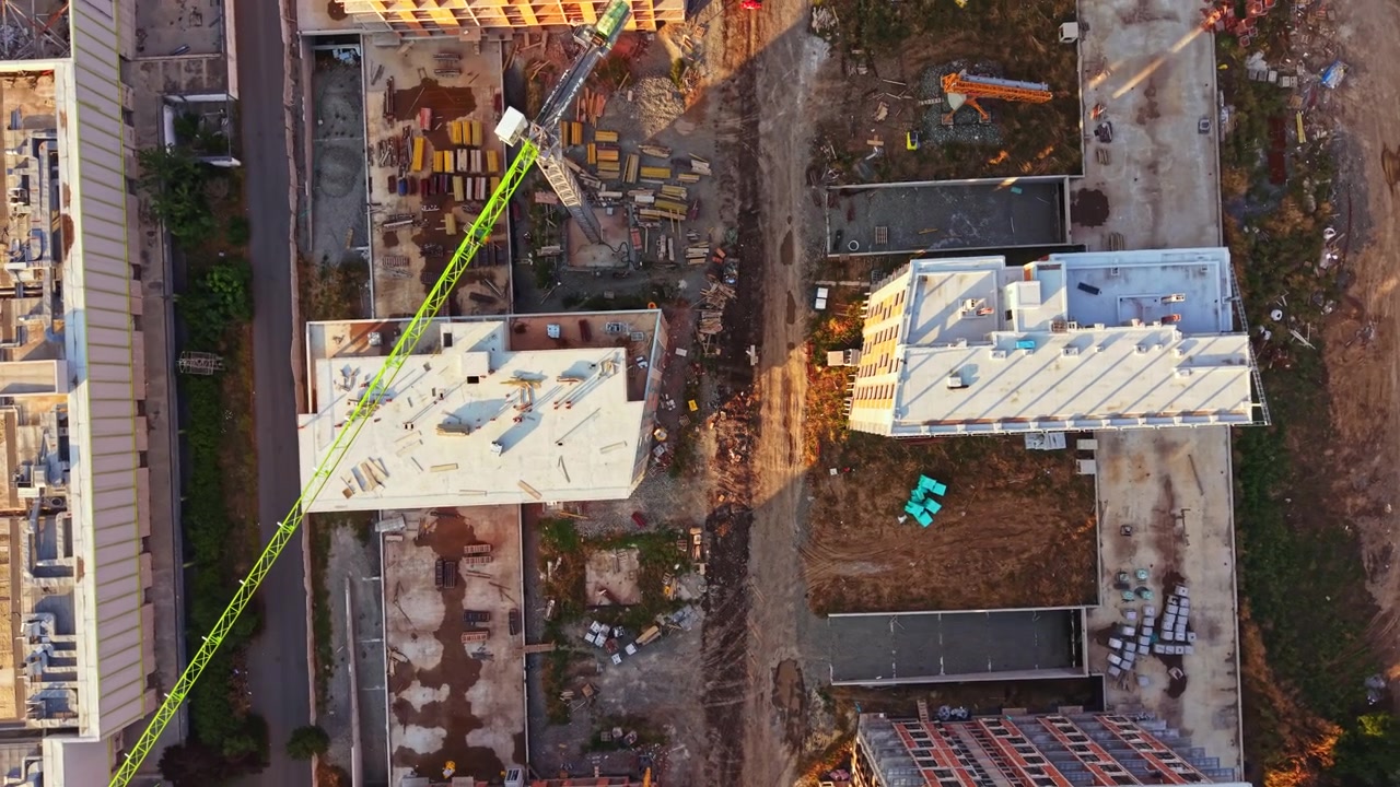 Byggeplads i et byområde, der viser byggefremskridt og udstyr under klar himmel i dagslys.