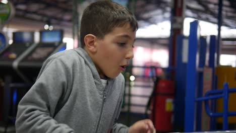 Un-Niño-Se-Divierte-Jugando-Juegos-Intermedios-En-Una-Sala-De-Juegos