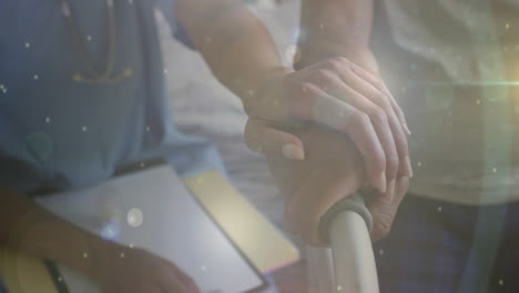 animación de puntos de luz sobre diversos médicos y pacientes que se toman de la mano.