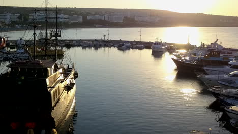 toma aérea de un pequeño puerto turístico y pesquero al amanecer