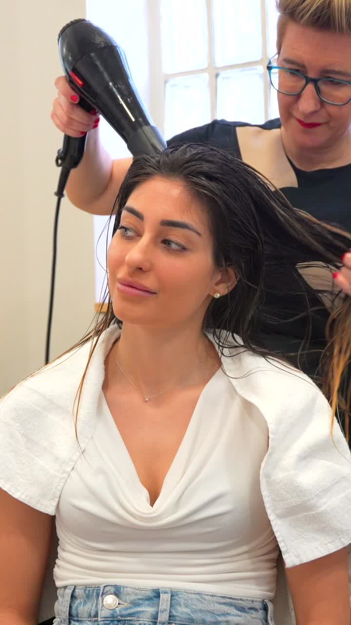 Mujer peinándose en una peluquería