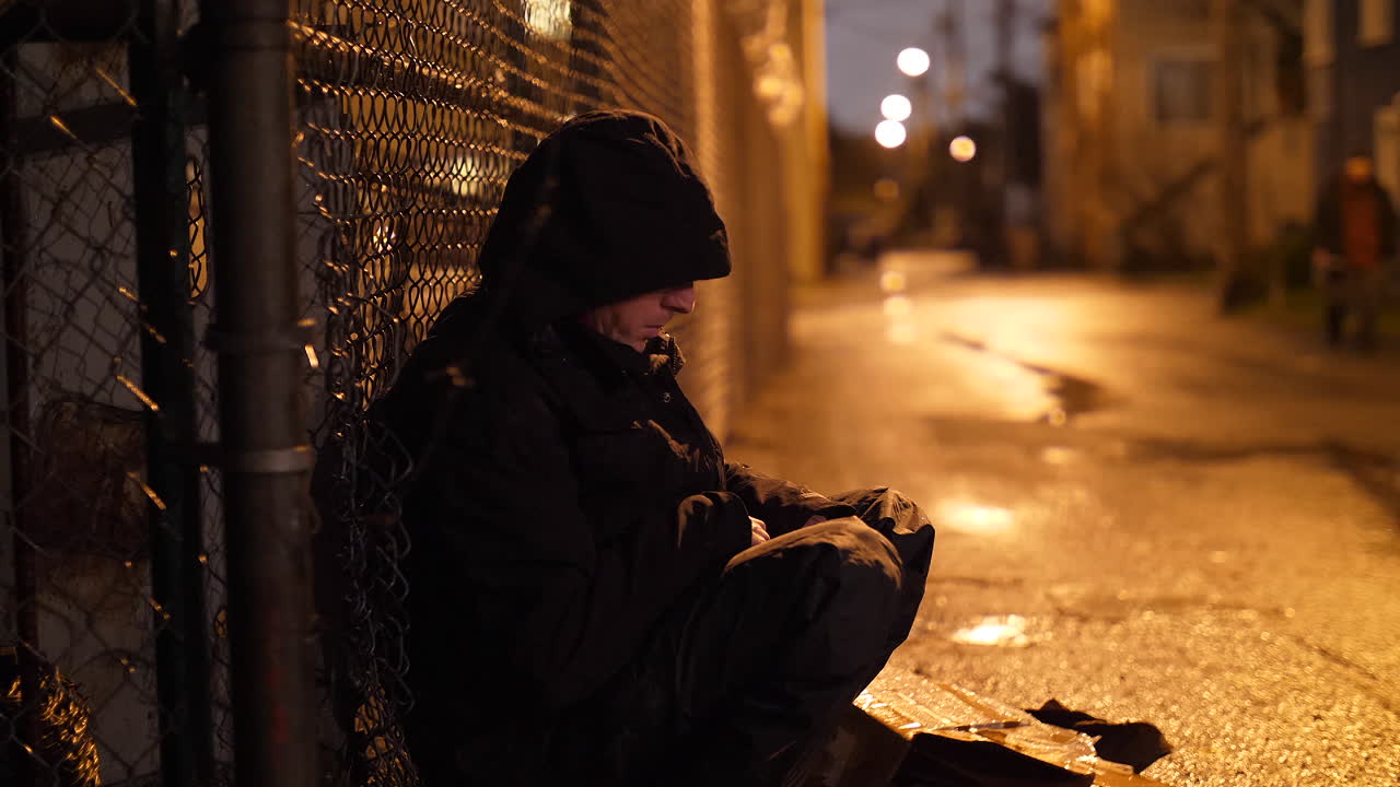 빗속에서 골목에 앉아 외로운 남자