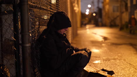 lonely man sitting in an alley in the rain