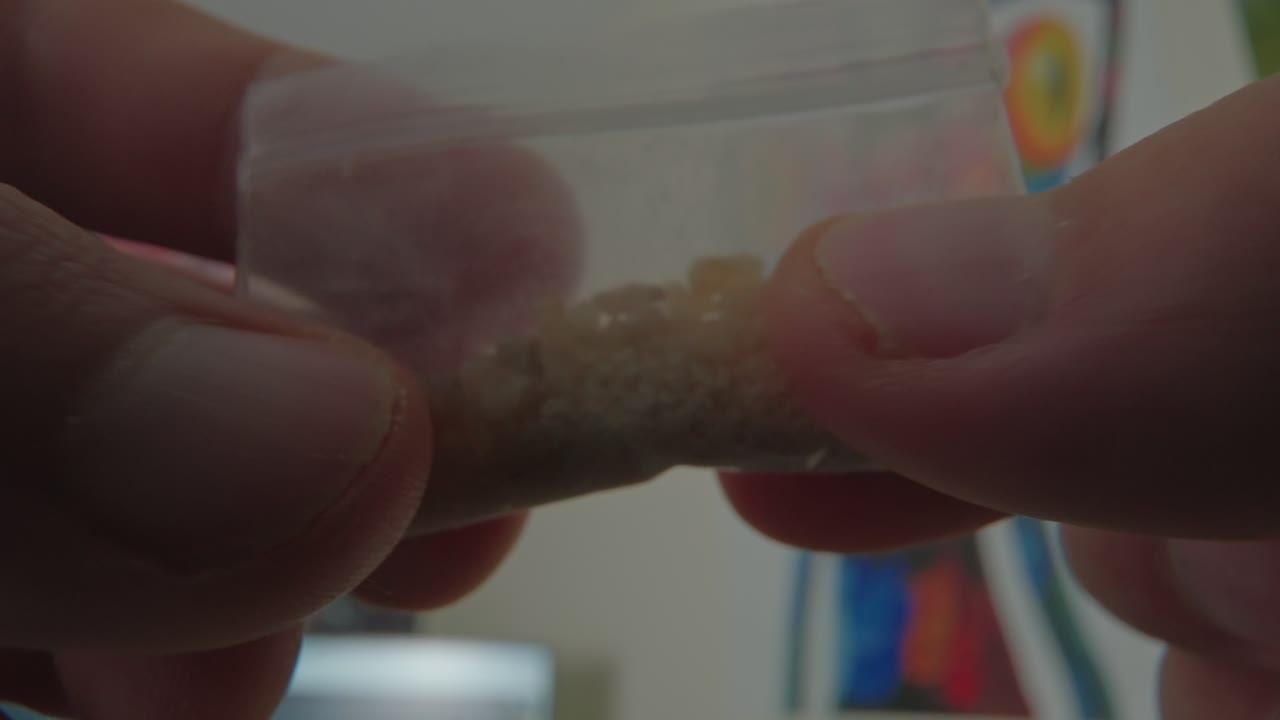 bolsa de cristales de mdma explorada por las manos