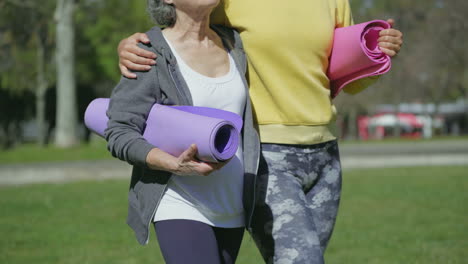 Cuerpos-Femeninos-Abrazándose-Con-Una-Estera-De-Yoga-En-Las-Manos