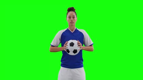 Video-of-caucasian-female-football-player-holding-football-and-copy-space-on-green-screen