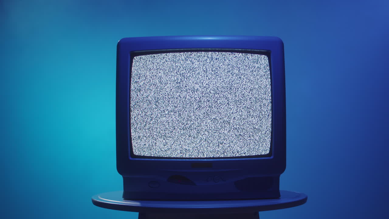 Telewizor vintage ze śnieżeniem na niebieskim tle