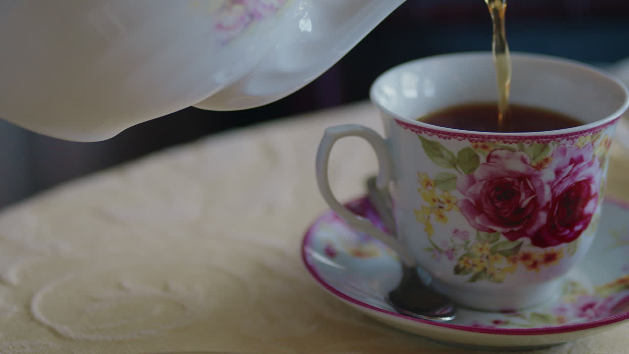 la taza de té de la flor rosa está llena de té caliente