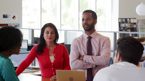 Black-male-manager-and-colleagues-standing-in-a-team-meeting