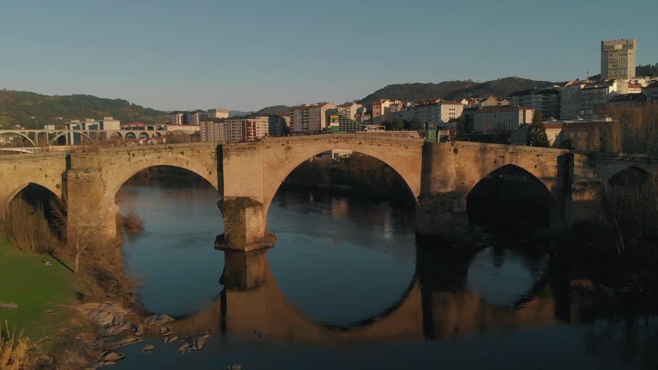 View Of Ponte Vella, A Roman Bridge Spanning Across The Minho River In Ourense, Galicia, Spain - drone shot (approaching)
