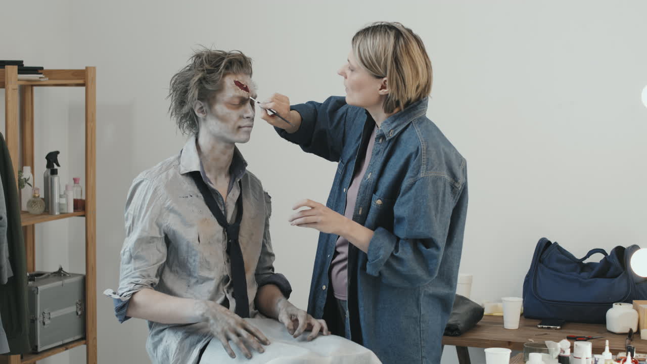 Woman Doing SFX Zombie Makeup on Man