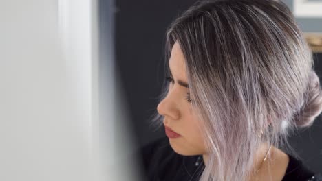 young lovely latina painter seriously working on her artwork