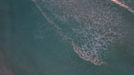 Top-view-of-rolling-ocean-waves-breaking-on-sand-bar-off-coast-of-Cancun,-Mexico