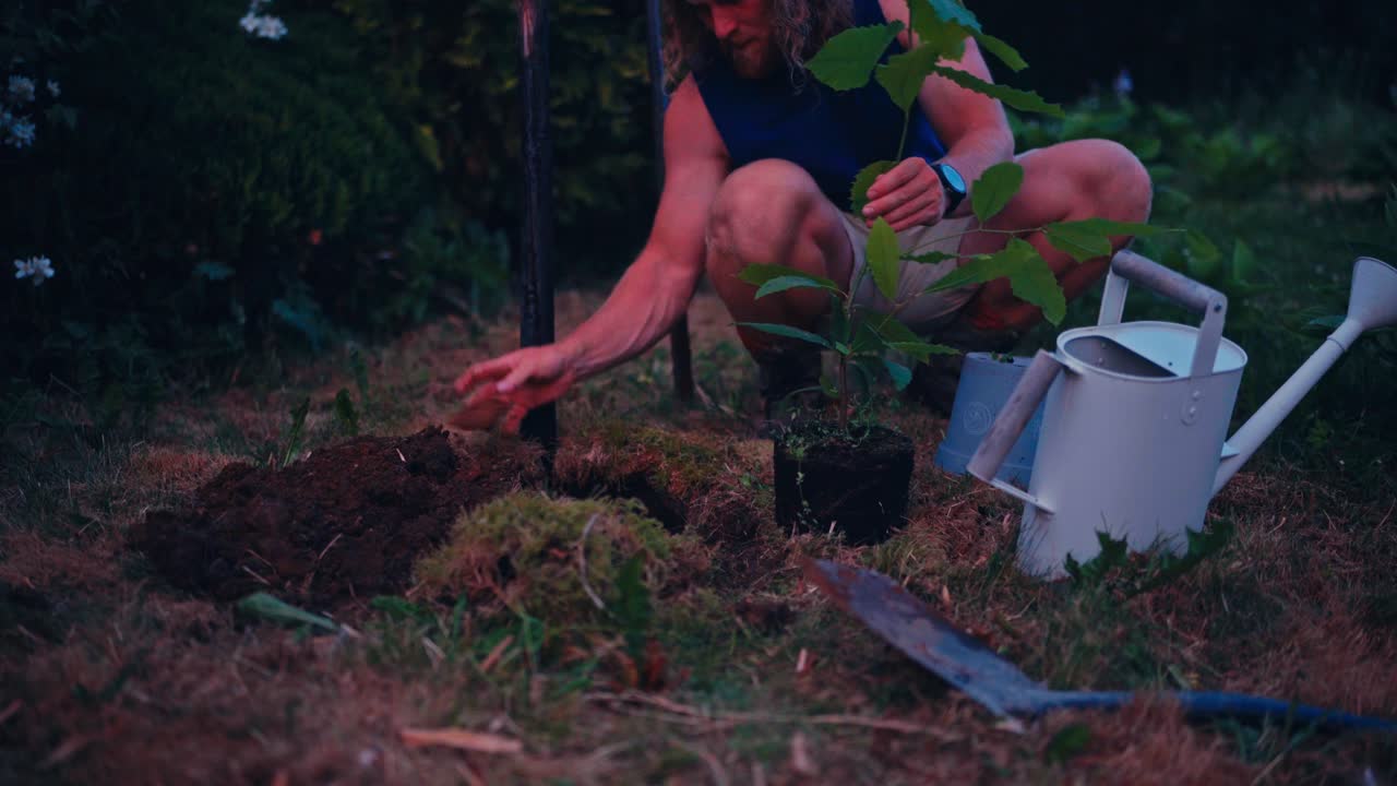A Man is Removing a Plant From its Pot, Preparing to Place it Into the Soil for Planting - Close Up