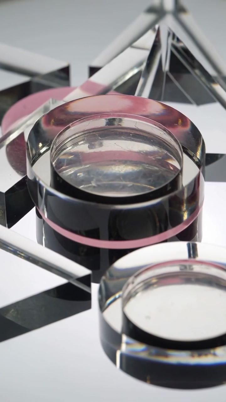 Vertical video: Panning camera revealing glass discs, prism on mirror for ad, showing pink lens