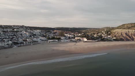 postal de praia da luz envuelta por una cálida y tranquila puesta de sol, algarve