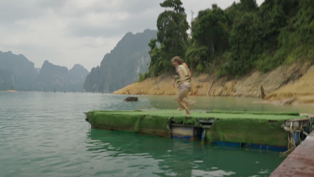 People enjoying a refreshing jump and swim in a beautiful lake surrounded by mountains