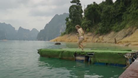 people enjoying a refreshing jump and swim in a beautiful lake surrounded by mountains