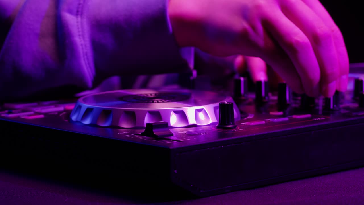 DJ with headphones and sunglasses playing music on festival in night club. Techno musician performing at nightclub for concert crowd of people, city bar.