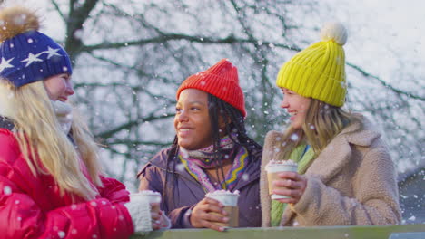 Porträt-Von-Mädchen-Im-Teenageralter,-Die-Gemeinsam-Heiße-Schokolade-Auf-Einem-Verschneiten-Winterspaziergang-In-Der-Landschaft-Genießen