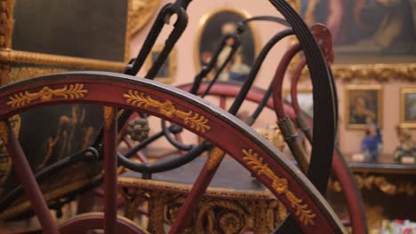 close up shot of a horse drawn carriage, showing wheels spokes, hub and suspension