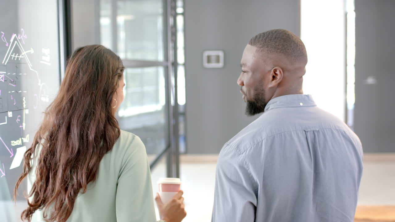 Walking and talking in modern office hallway, business professionals