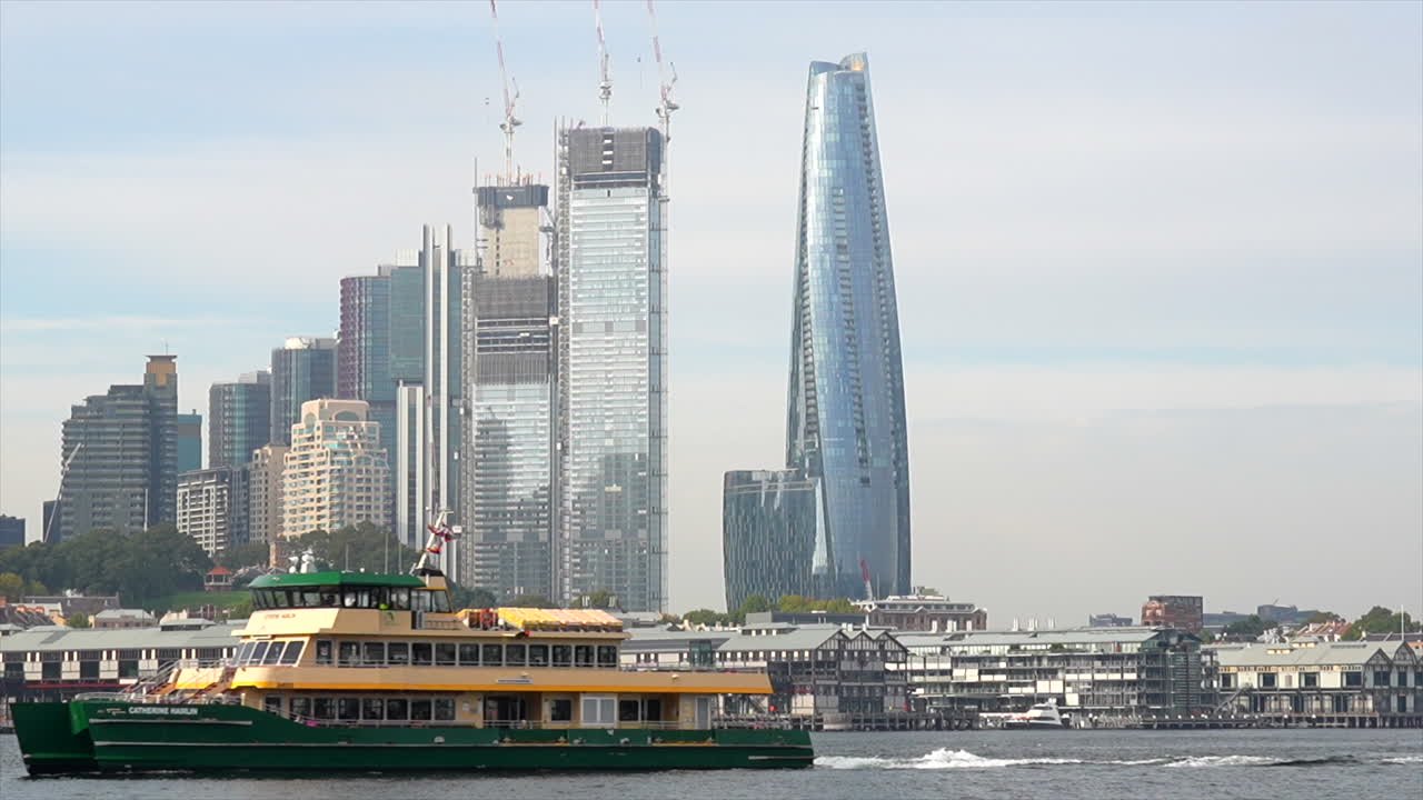 un ferry de sydney pasa por altos rascacielos en el puerto de sydney, australia