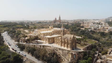 4k aerial drone footage circling the church ghajnsielem parish in the mediterranean town of mgarr - gozo, malta