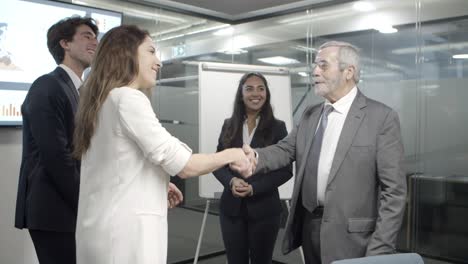 Grupo-De-Trabajadores-De-Oficina-Sonrientes-Dándose-La-Mano-En-La-Oficina