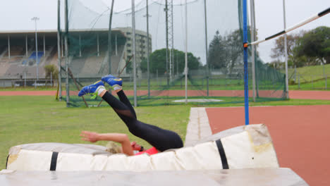 side view of caucasian female athlete practicing high jump at sports venue 4k